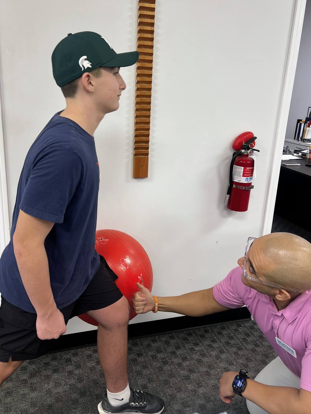 A therapist giving a patient a thumbs up during strength work