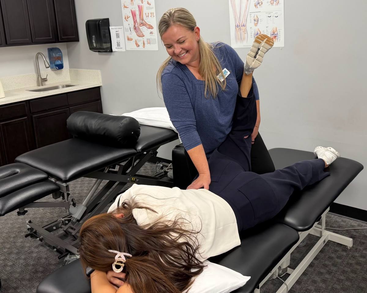 A therapist examining a patient on the treatment table